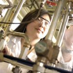 student in lab with distillation equipment
